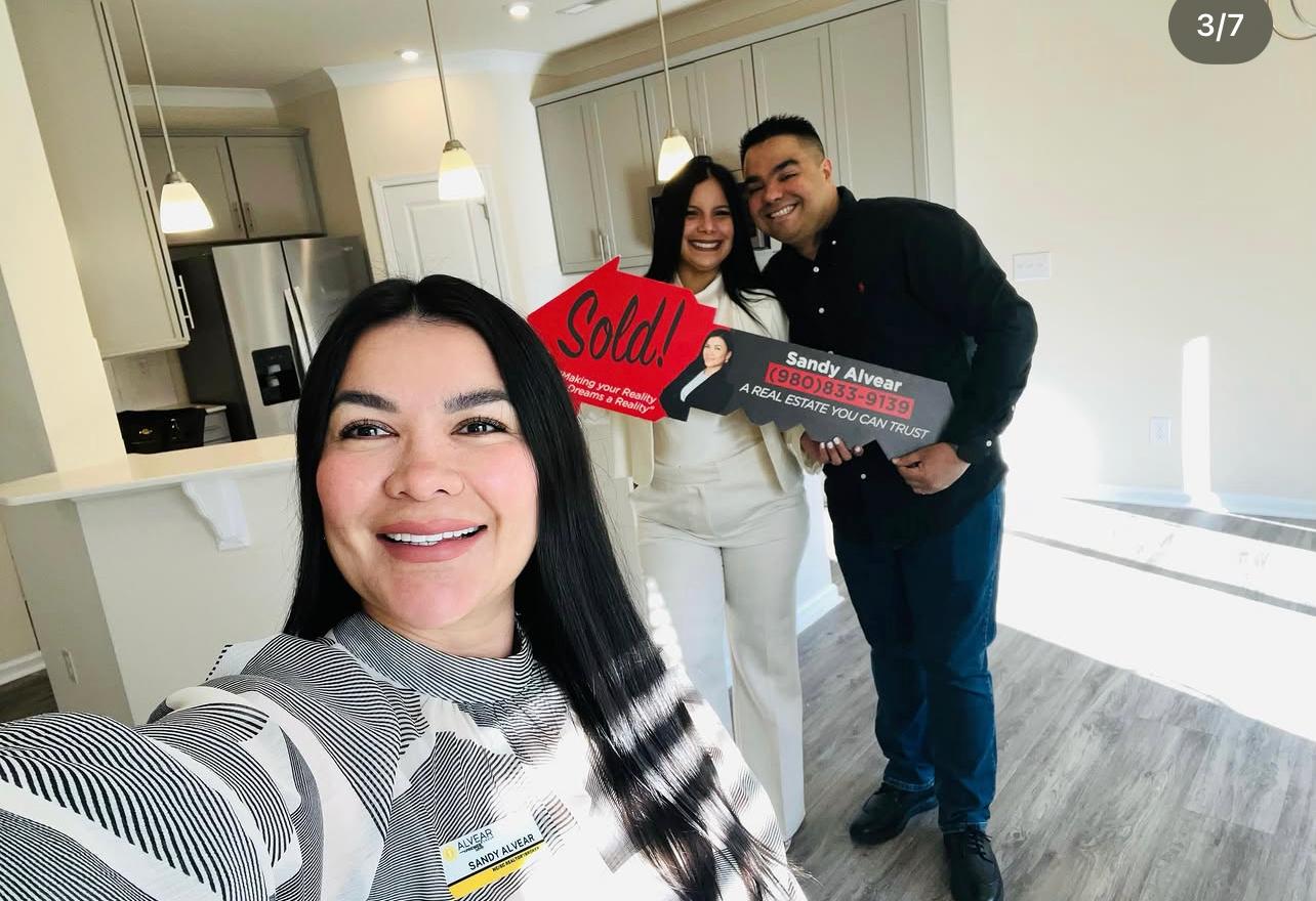 Sandy Alvear selfie with happy clients at new home interior