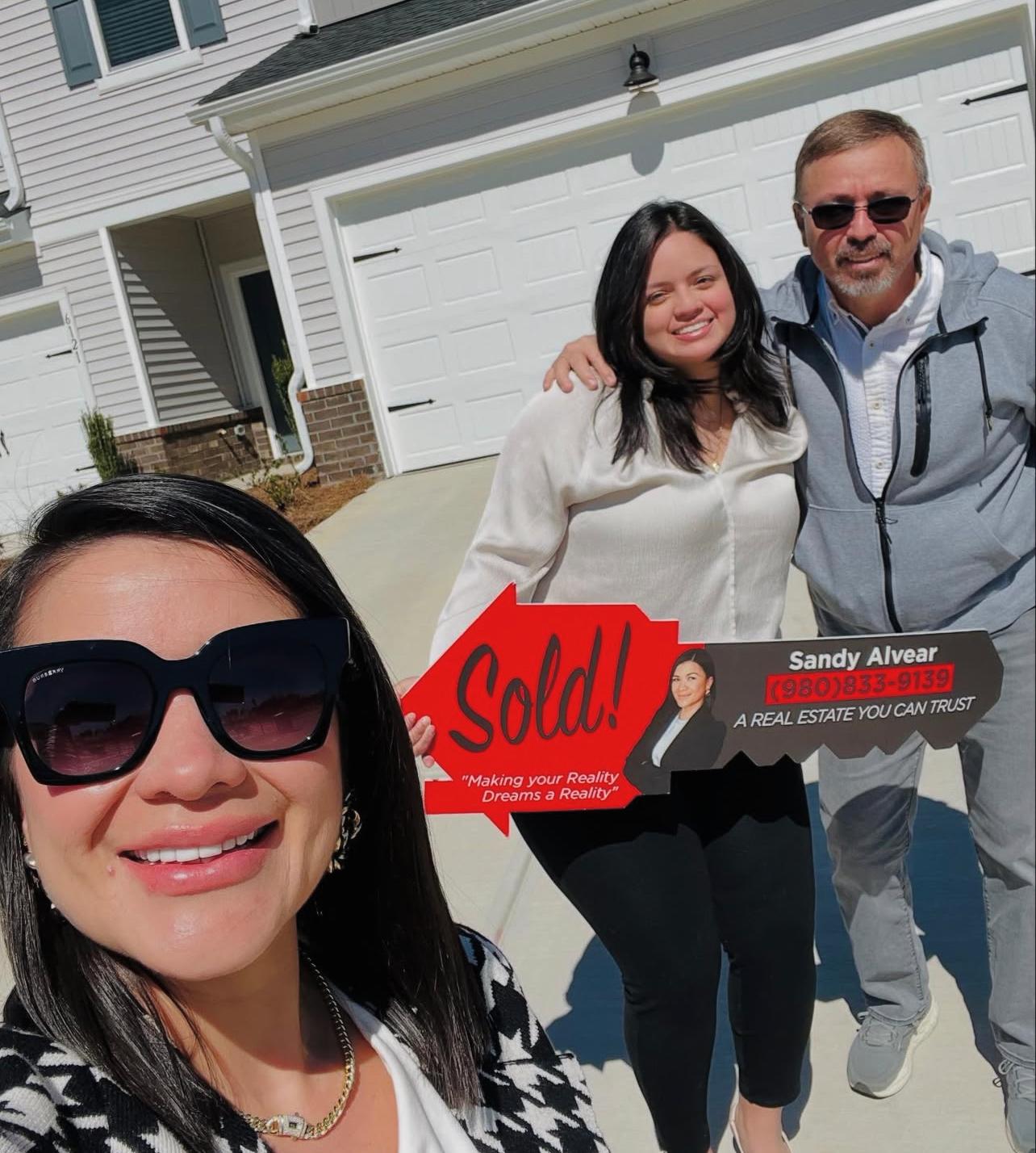 Sandy Alvear with client in front of their new home